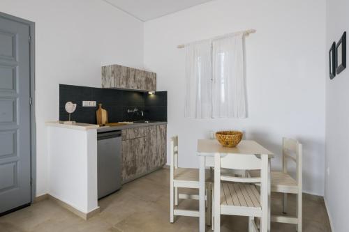 a kitchen with a table and a small table and chairs at Scala Apartments in Kastraki Naxou