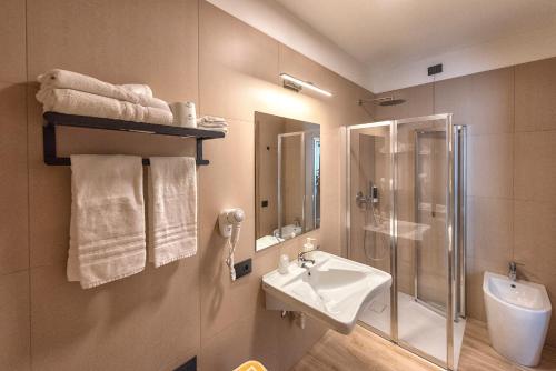 a bathroom with a sink and a shower and a toilet at Hotel Golf ***S in Bibione