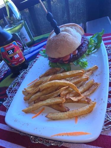 a plate with a sandwich and french fries on a table at Sunrise Beach Lodge in Ponta Malongane