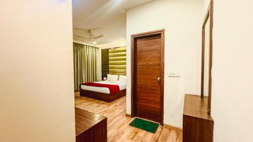 a hotel room with a bed and a door at Hotel Bahl Regency in Zirakpur