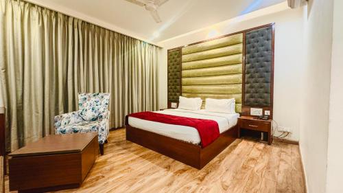 a bedroom with a bed and a desk and a chair at Hotel Bahl Regency in Zirakpur