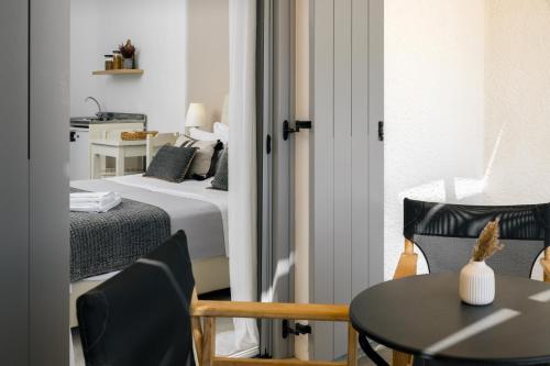 a bedroom with a bed and a table and chairs at Scala Apartments in Kastraki Naxou