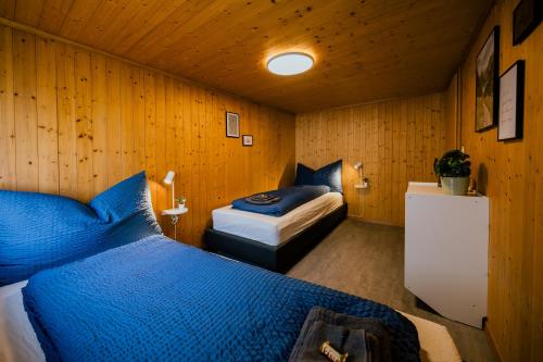 a bedroom with two beds in a room with wooden walls at Mountain View near Brienz - free parking in Kienholz