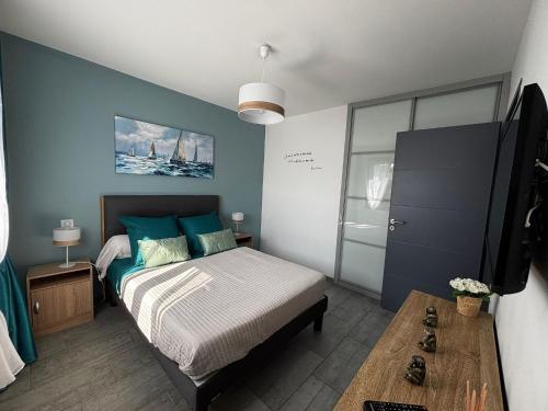 une chambre avec un lit et un mur bleu dans l'établissement Superbe villa 6 personnes proche océan et lac, à Linxe
