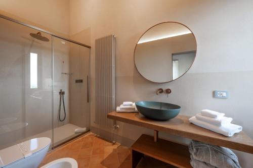 a bathroom with a bowl sink and a mirror at Nobilis Charme Relais in Montepulciano