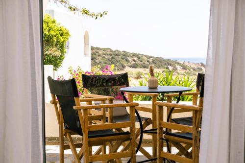 a patio with a table and chairs on a balcony at Scala Apartments in Kastraki Naxou