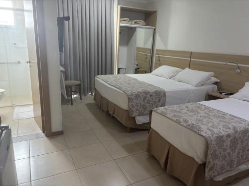 a hotel room with two beds and a bathroom at Varadero Palace Hotel in Florianópolis