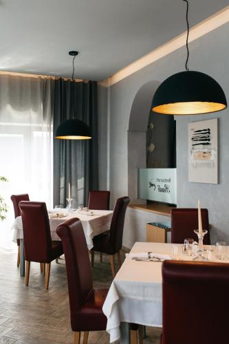 a dining room with tables and chairs and lights at Villa Badi in Umag