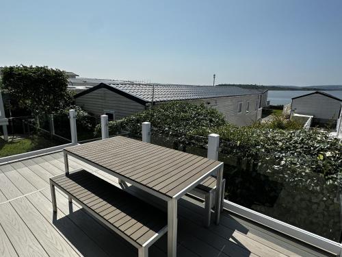 a wooden table and bench sitting on a deck at Rockley Park Private Holiday Homes in Poole