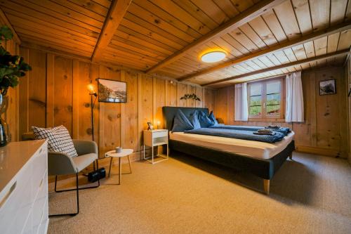 a bedroom with a bed and a chair in a room at Mountain View near Brienz - free parking in Kienholz