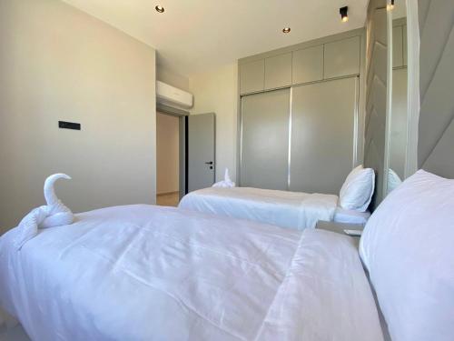 a bedroom with two beds with white sheets at Via Mar Residence - Alanya Experience in Alanya