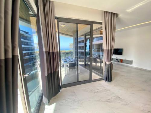 a living room with sliding glass doors and a dining room at Via Mar Residence - Alanya Experience in Alanya