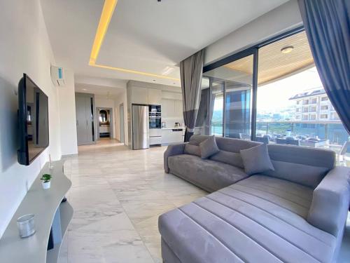 a living room with a couch and a large window at Via Mar Residence - Alanya Experience in Alanya