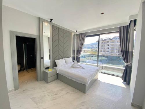 a bedroom with a bed and a large window at Via Mar Residence - Alanya Experience in Alanya