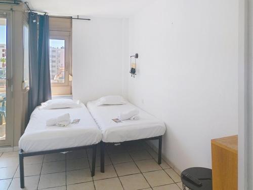 deux lits dans une chambre avec une fenêtre dans l'établissement Résidence Graziella Studio 423, à Juan-les-Pins