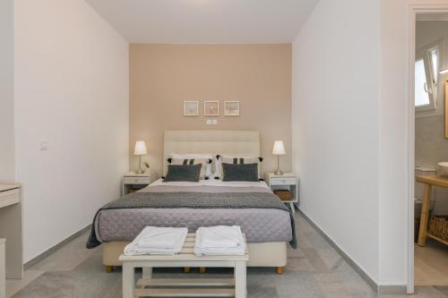 a bedroom with a large bed and two tables at Scala Apartments in Kastraki Naxou