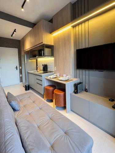 a living room with a large bed and a kitchen at Cozy and complete studio - Brooklin SP in Sao Paulo