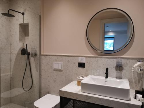 a bathroom with a sink and a mirror at Atlas Aparthotel in Piatra Neamţ
