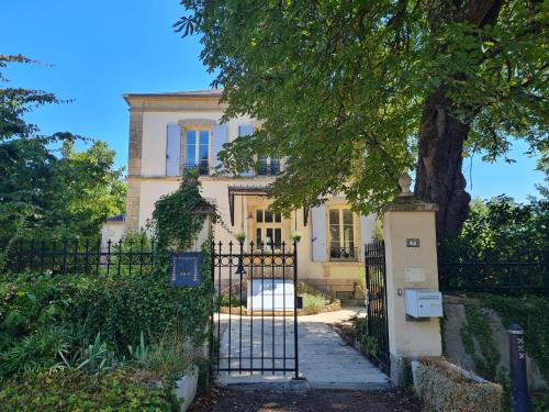 a white house with a gate and a tree at Presbytère in Marigny-sur-Yonne