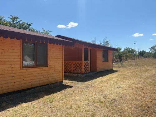 a small wooden cabin with a window on a field at Camping mery in Murighiol