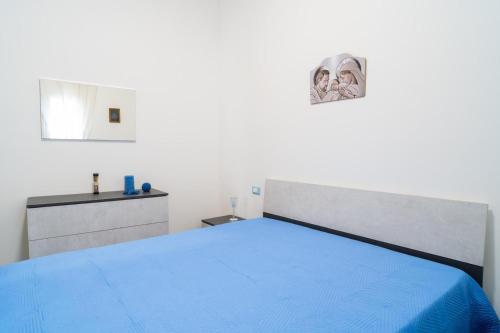 een slaapkamer met een blauw bed en een dressoir bij Casa vacanze CaMi in Alcamo