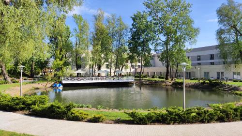 a bridge over a river in a park at Green Garden Hotel in Raszyn
