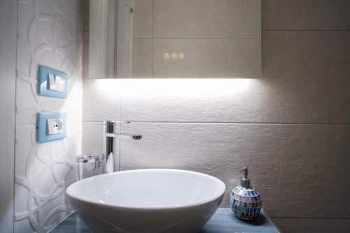 een badkamer met een witte wastafel en een spiegel bij Casa vacanze CaMi in Alcamo
