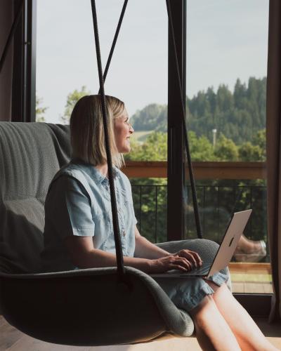 a woman sitting in a swing with a laptop at KaiserMoments in Going