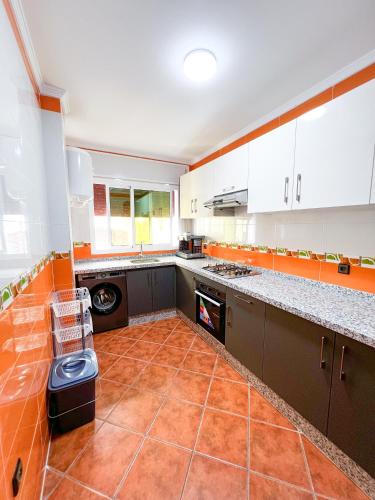 a kitchen with an orange tile floor and white cabinets at Appart-hôtel Costa Azul - Richa in Oued Laou
