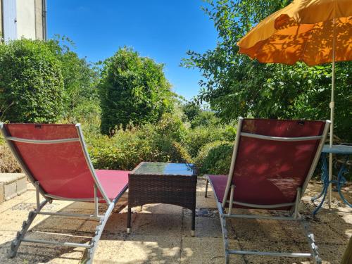 two chairs and a table and an umbrella at Presbytère in Marigny-sur-Yonne