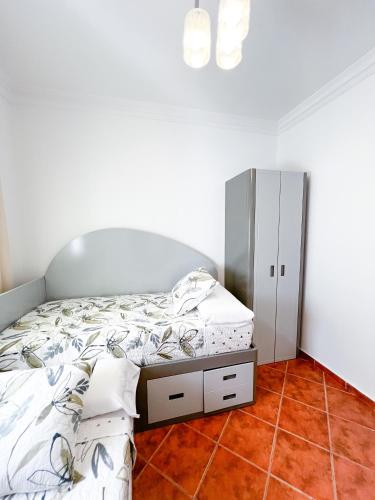 a bedroom with a bed and a cabinet at Appart-hôtel Costa Azul - Richa in Oued Laou