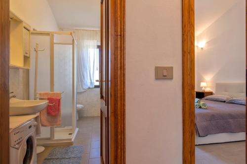 a bathroom with a sink and a bedroom with a bed at Rose's House in Trinità dʼAgultu