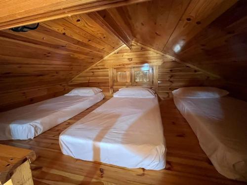 una habitación con dos camas en una cabaña de madera en Alixares de Güéjar Sierra, en Güéjar-Sierra