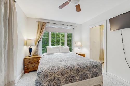 une chambre blanche avec un lit et une fenêtre dans l'établissement Dogwood Cottage, à Bar Harbor