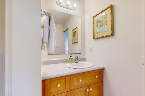 une salle de bain avec un lavabo et un miroir dans l'établissement Dogwood Cottage, à Bar Harbor