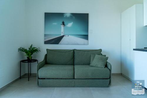 a living room with a couch in front of a lighthouse at Villa Mediterranea Apartments - Seaview, Pool & Garden in Bari