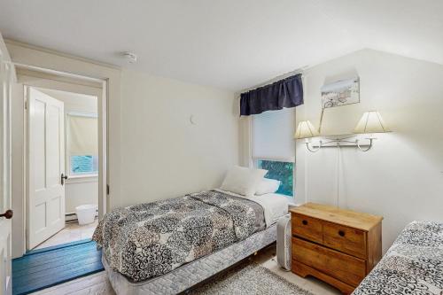 una camera da letto con due letti e una finestra di Norris Cottage a Bar Harbor