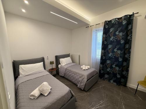 a bedroom with two beds and a window at Borbon Home luxury rooms & SPA in Palermo