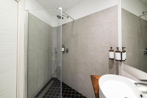 a bathroom with a shower and a white sink at Phi Hotel Milano in Baranzate