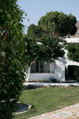 a white house with trees in front of it at Scala Apartments in Kastraki Naxou