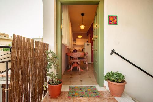 a small balcony with a table and potted plants at Yiayia's Guesthouse in Ipsos