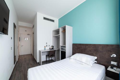 a bedroom with a bed and a desk in it at Phi Hotel Milano in Baranzate