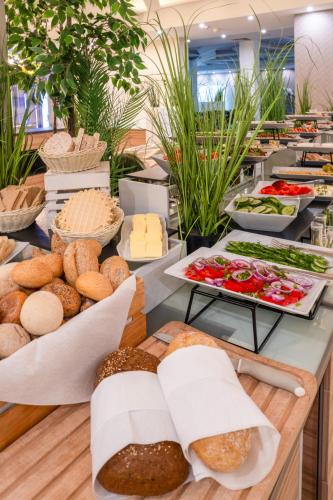 a buffet with bread and other foods on a table at Green Garden Hotel in Raszyn