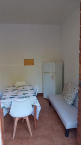 ein Wohnzimmer mit einem Tisch, einem Sofa und einem Kühlschrank in der Unterkunft Casa Manto in Mantua