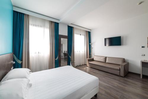 a hotel room with a bed and a couch at Phi Hotel Milano in Baranzate