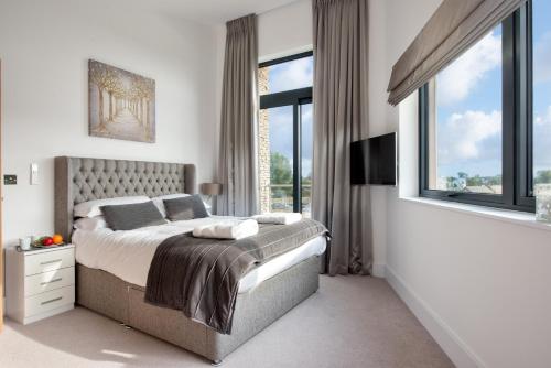 een slaapkamer met een bed en een groot raam bij The Cotswolds Manor ML26 Lower Mill Estate. in Somerford Keynes