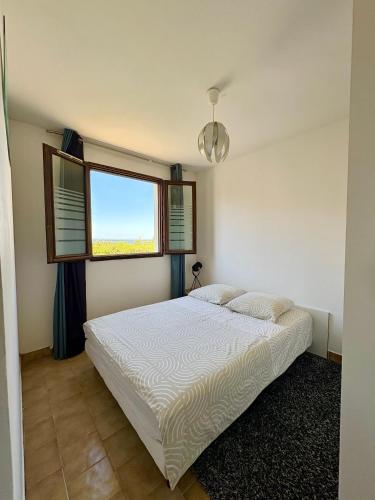 une chambre avec un lit et une fenêtre dans l'établissement Appartement T2 vue exceptionnelle CARNON-PLAGE, à Carnon-Plage