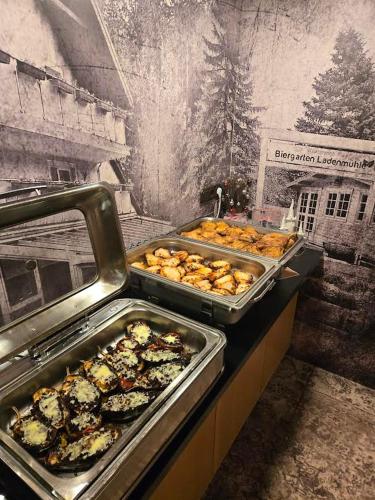 a buffet with many trays of food on a table at Garden Depandance Am Bach in Kurort Altenberg