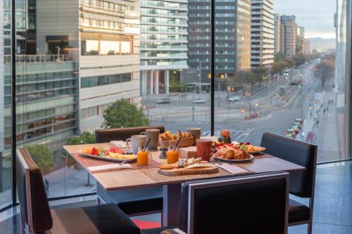 una mesa con comida y vistas a la ciudad en Leonardo Royal Hotel Barcelona Forum, en Barcelona