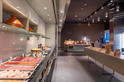 Una panadería con muchos tipos diferentes de alimentos en exhibición. en Leonardo Royal Hotel Barcelona Forum, en Barcelona